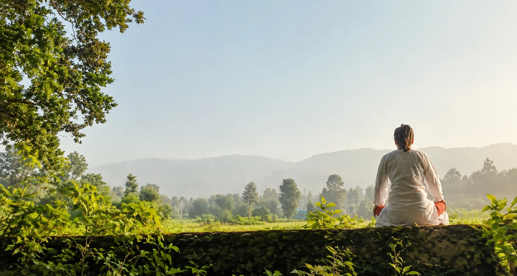 Person meditating in nature during a silent meditation retreat in Rishikesh, India